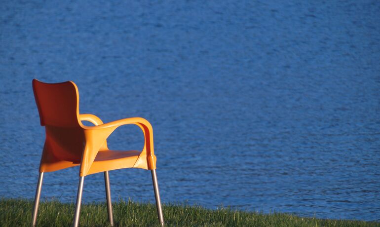 Ein Stuhl steht am Rand einer Wasserfläche